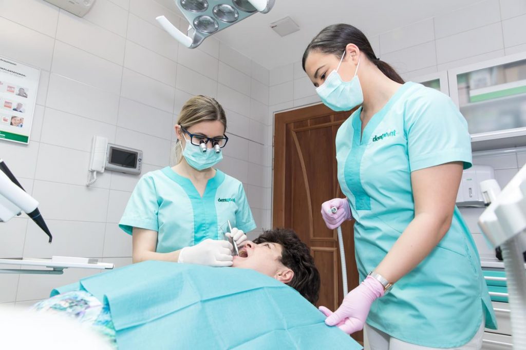 Fogágybetegség kezelése fogorvosi rendelőben egy dentálhigiénikus és egy fogorvos által.